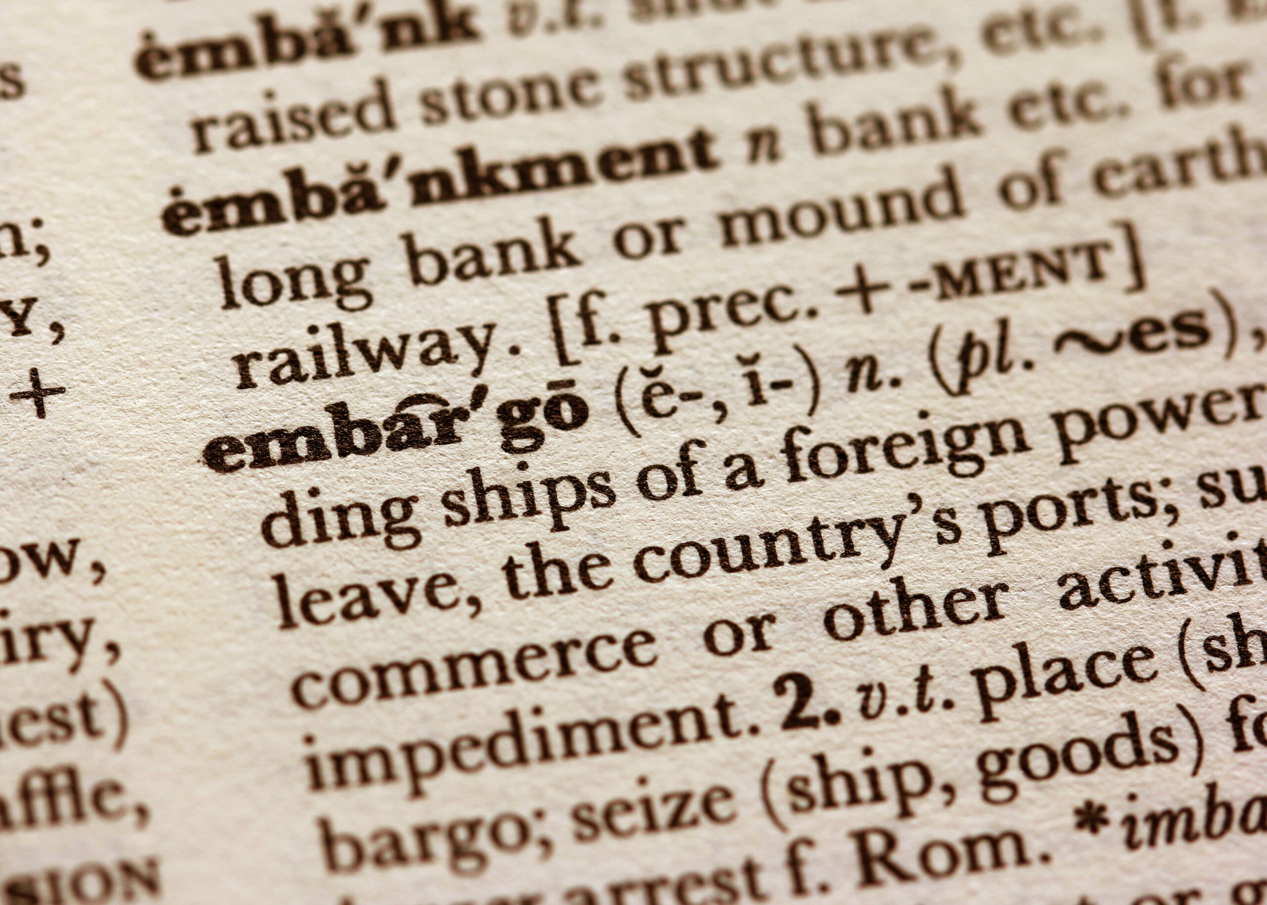 close up of a page in a dictionary, showing the definition of embargo