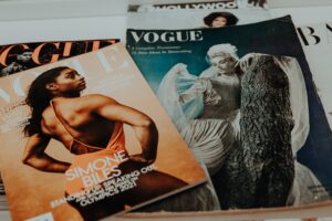 A selection of Vogue editions from different eras, with the tope one featuring gymnast Simone Biles.