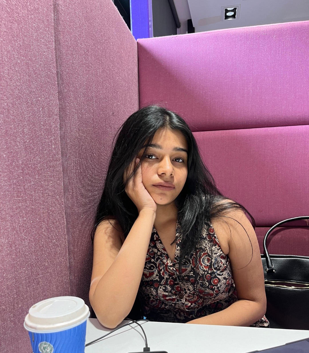 Khushi sits in a university booth which is purple