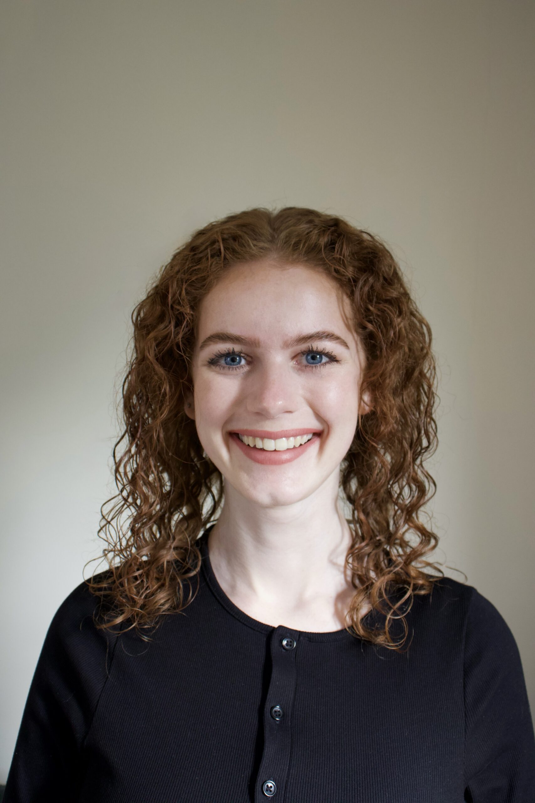 Grace, a white woman with red hair smiles to camera