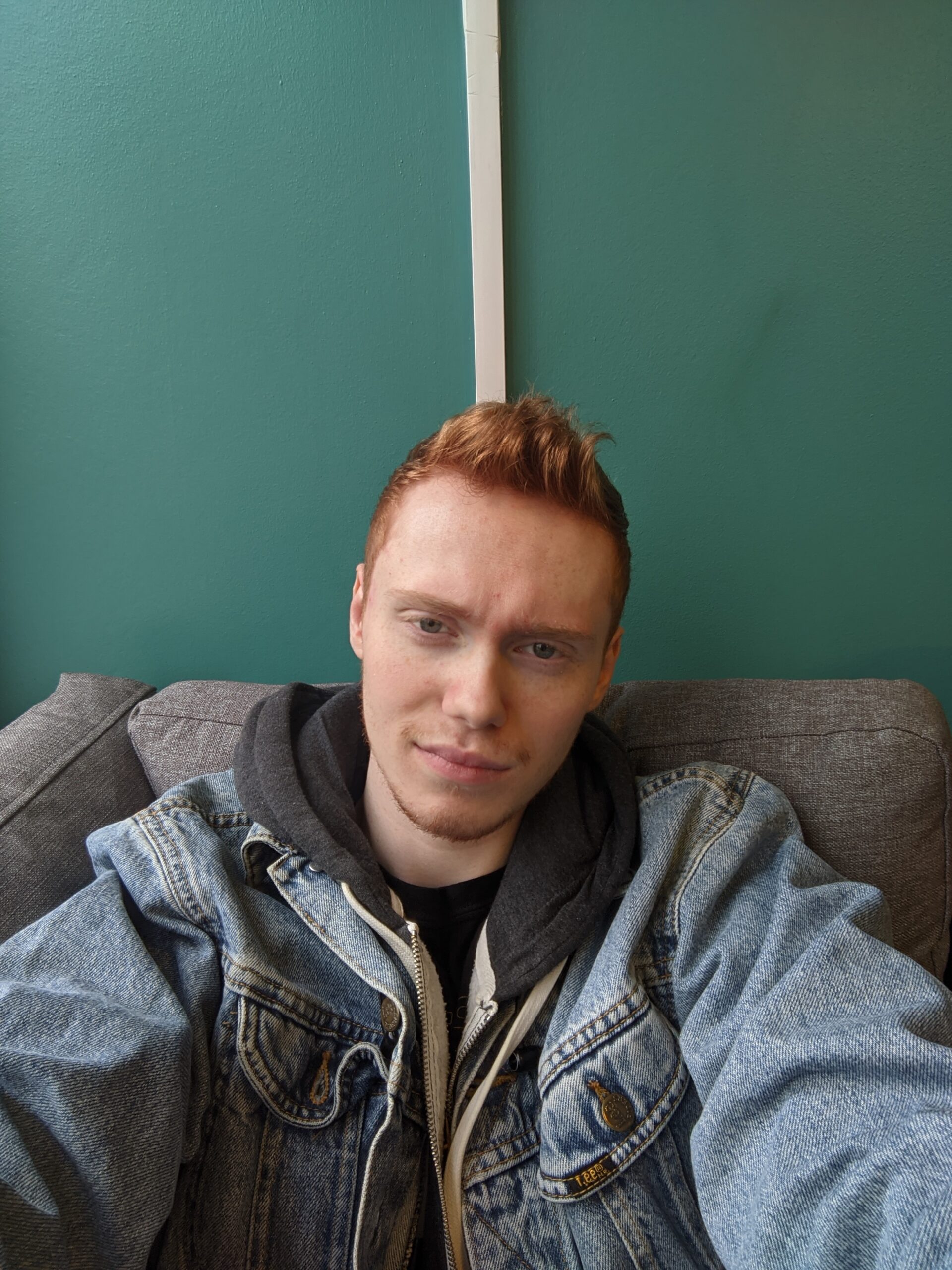 Connor looks to camera while wearing a blue demin jacket