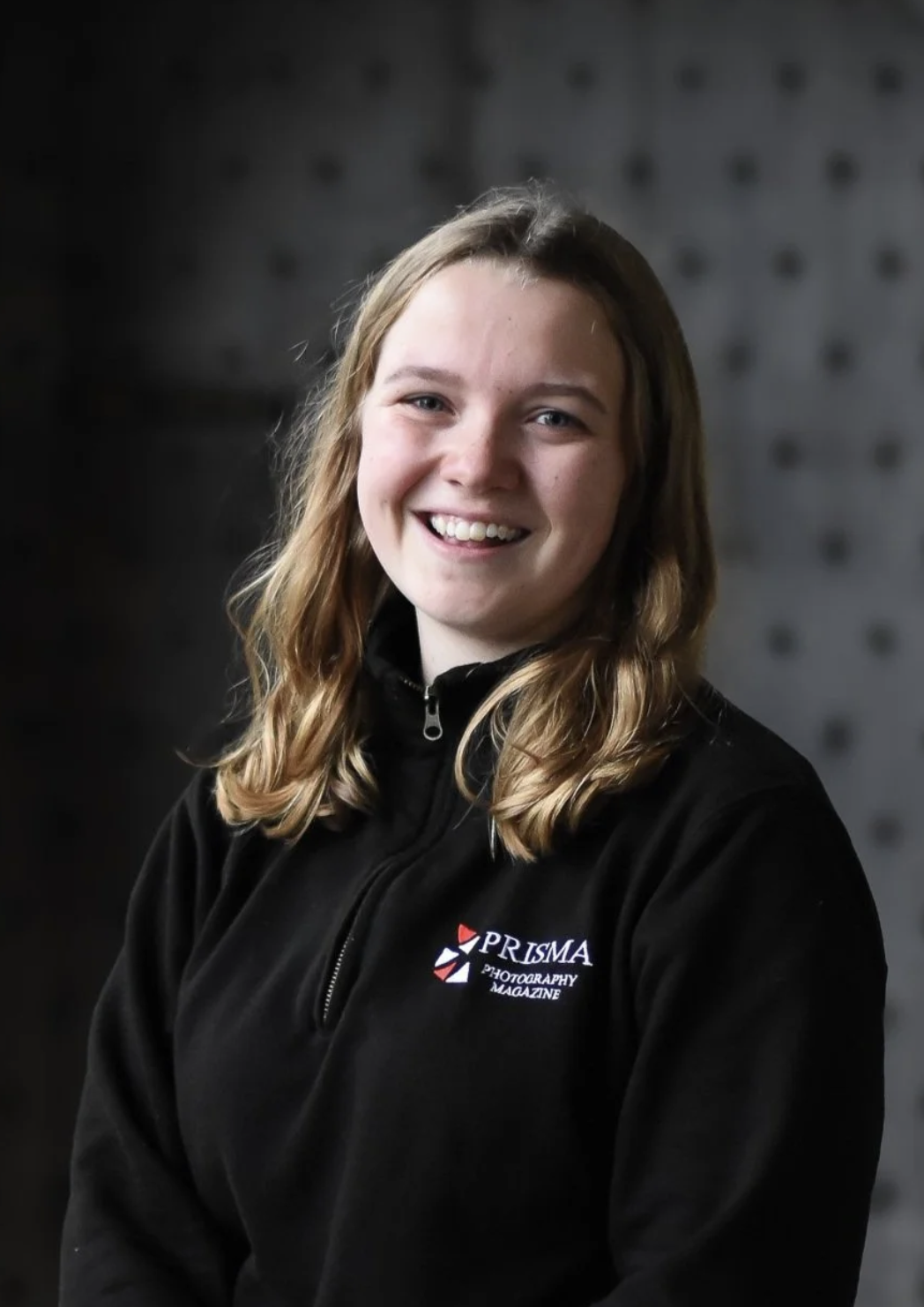 Louise Anderbjörk, a white woman with blonde hair, looks to camera smiling. She wears a black fleece.